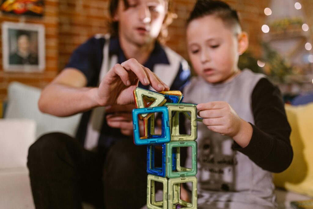 A father and son enjoying quality time building a tower with colorful magnetic blocks.